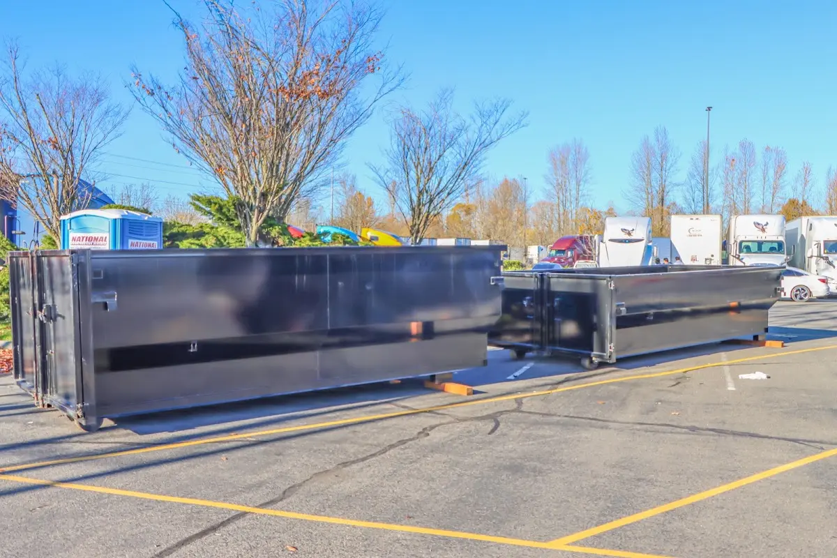 Professional dumpster rental service with roll-off container on residential driveway in Mila Doce